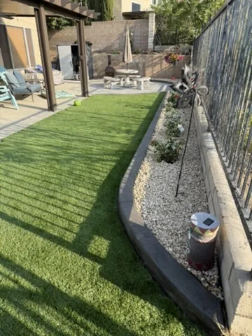 Block wall with an artificial turf terrace above and gravel drainage below in Orange County, California