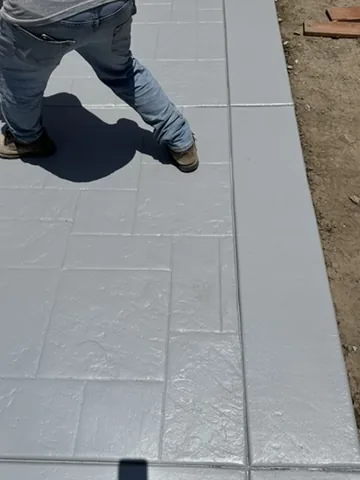 Crew member finishing the surface of a freshly poured concrete slab in Orange County, California