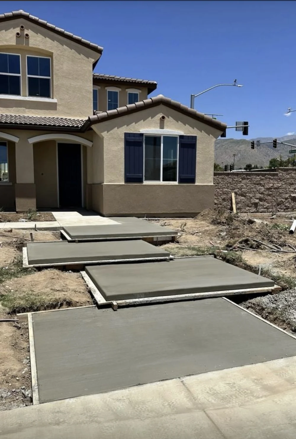 Freshly poured concrete walkway panels stepping down to the street at a new build in Orange County, California