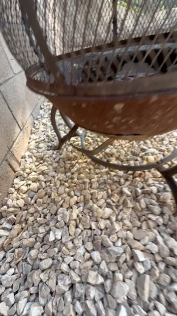 Steel fire bowl standing on a bed of white cobble in Orange County, California