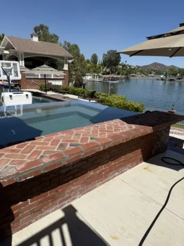 Raised brick planter beside a pool deck in Orange County, California