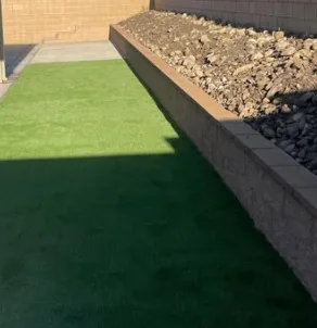 Artificial turf terrace above a block retaining wall filled with drainage rock in Orange County, California
